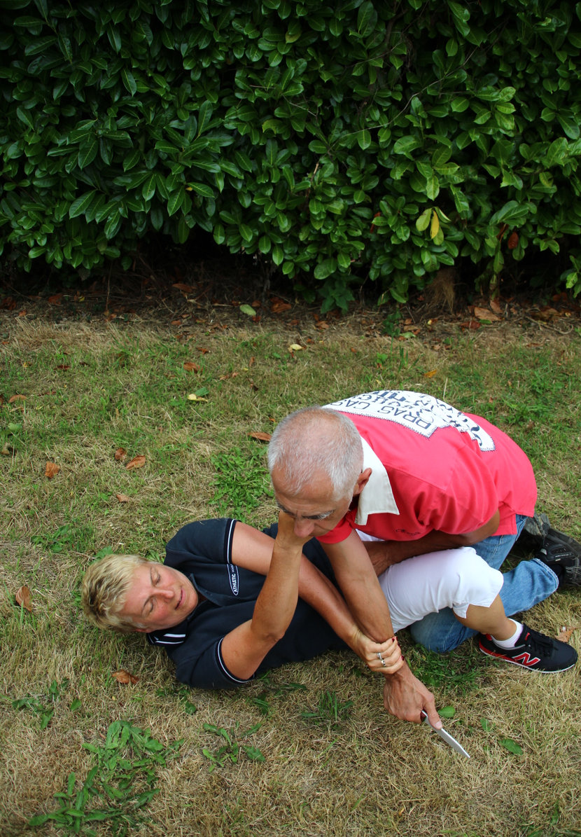 Femme au sol se défendant contre une arme blanche — stage self-défense ABKM